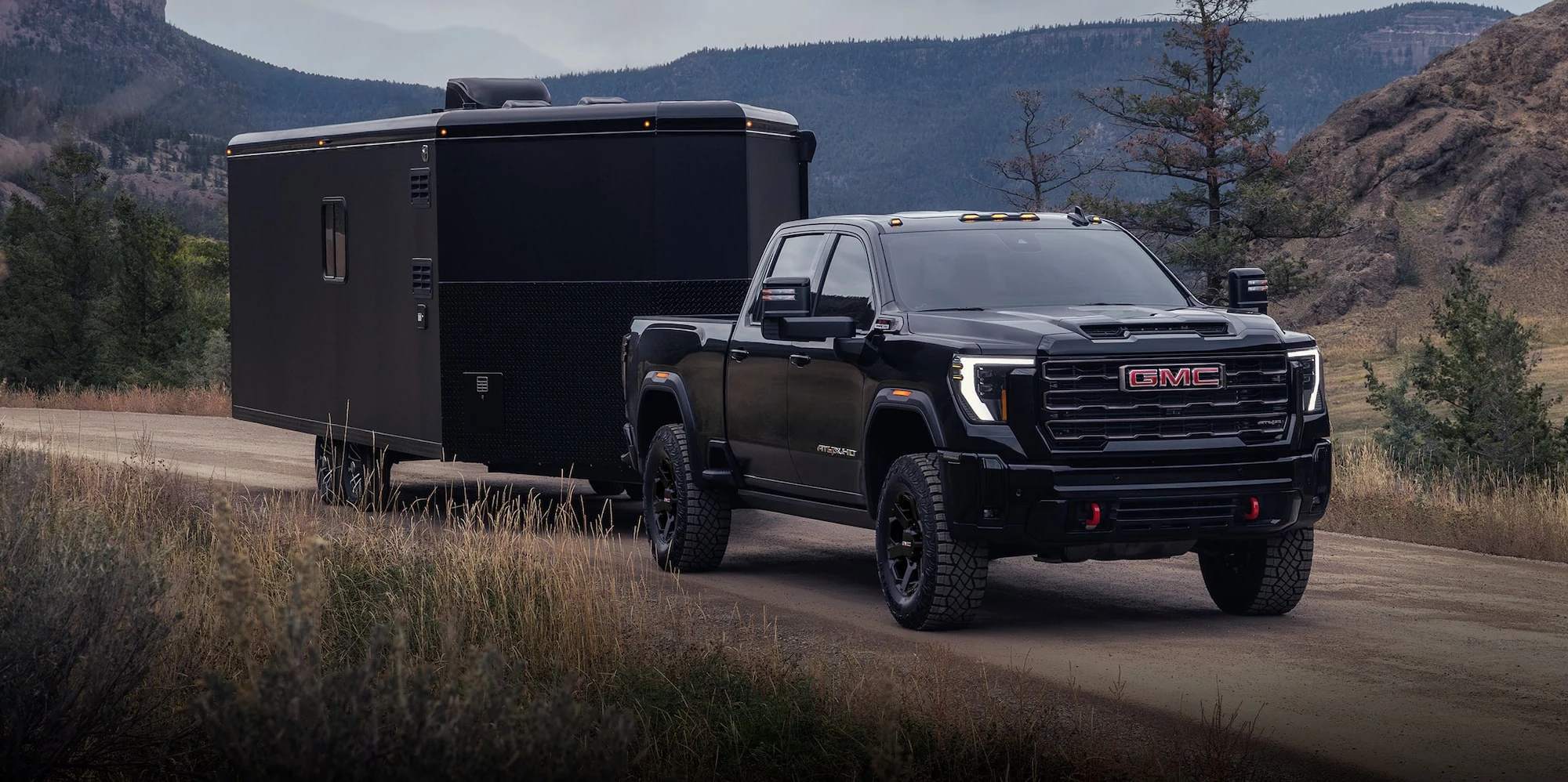 Black GMC Sierra HD towing an enclosed trailer