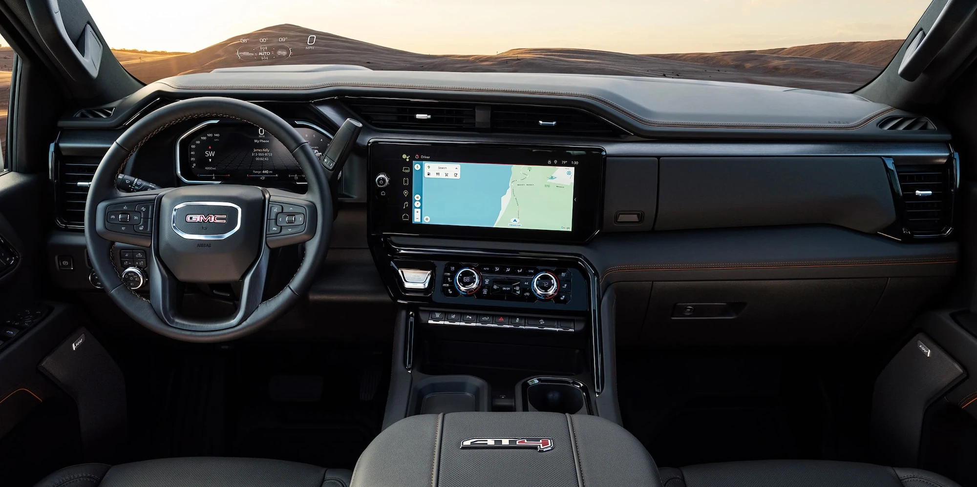 GMC Sierra HD dashboard with dark upholstery, orange accents and navigation screen