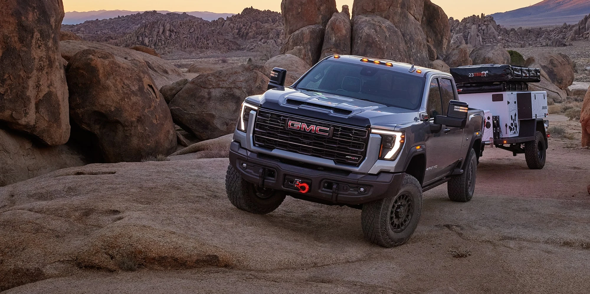 Gray GMC Sierra HD AT4X with an adventure trailer