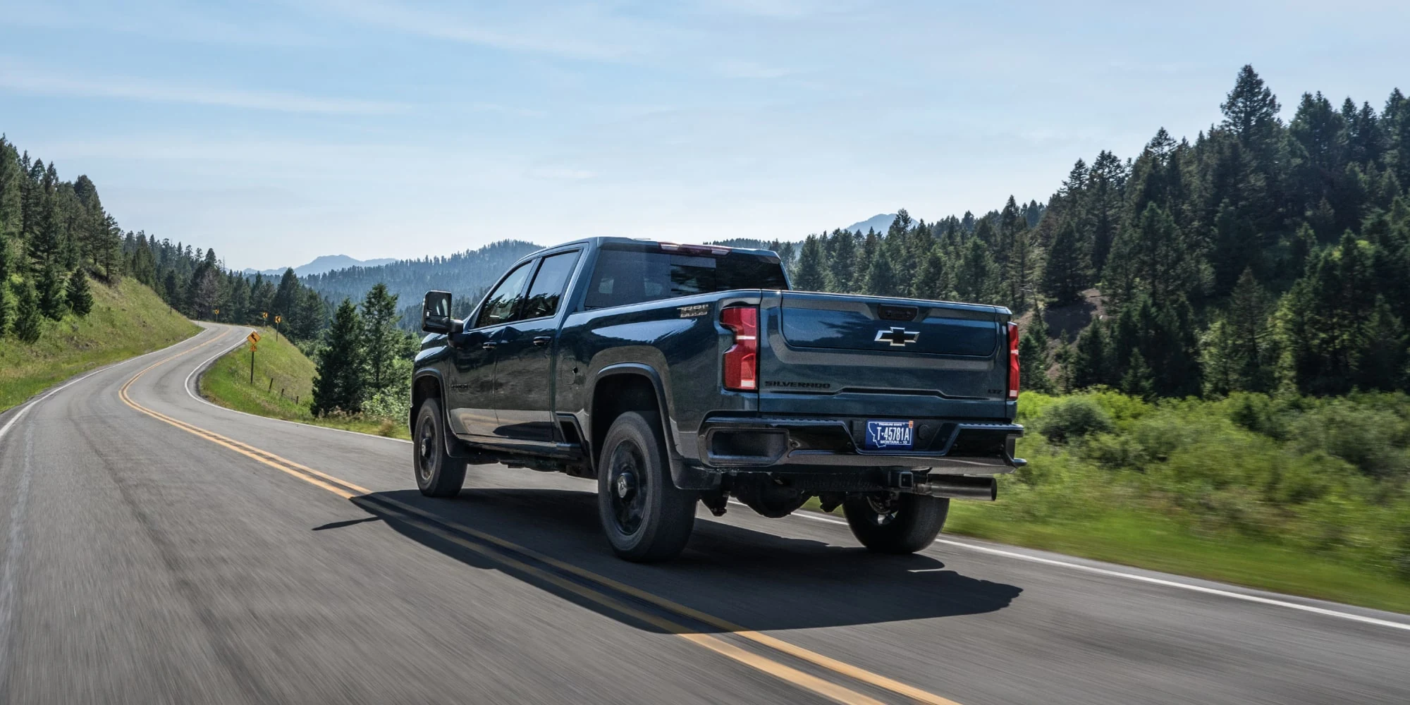 Black Chevrolet Silverado HD on the road, rear three-quarter view